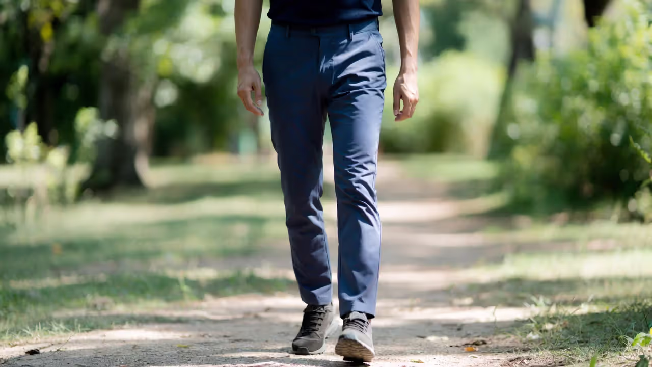 Adult walking outdoors in a park without phone, appearing calm and present